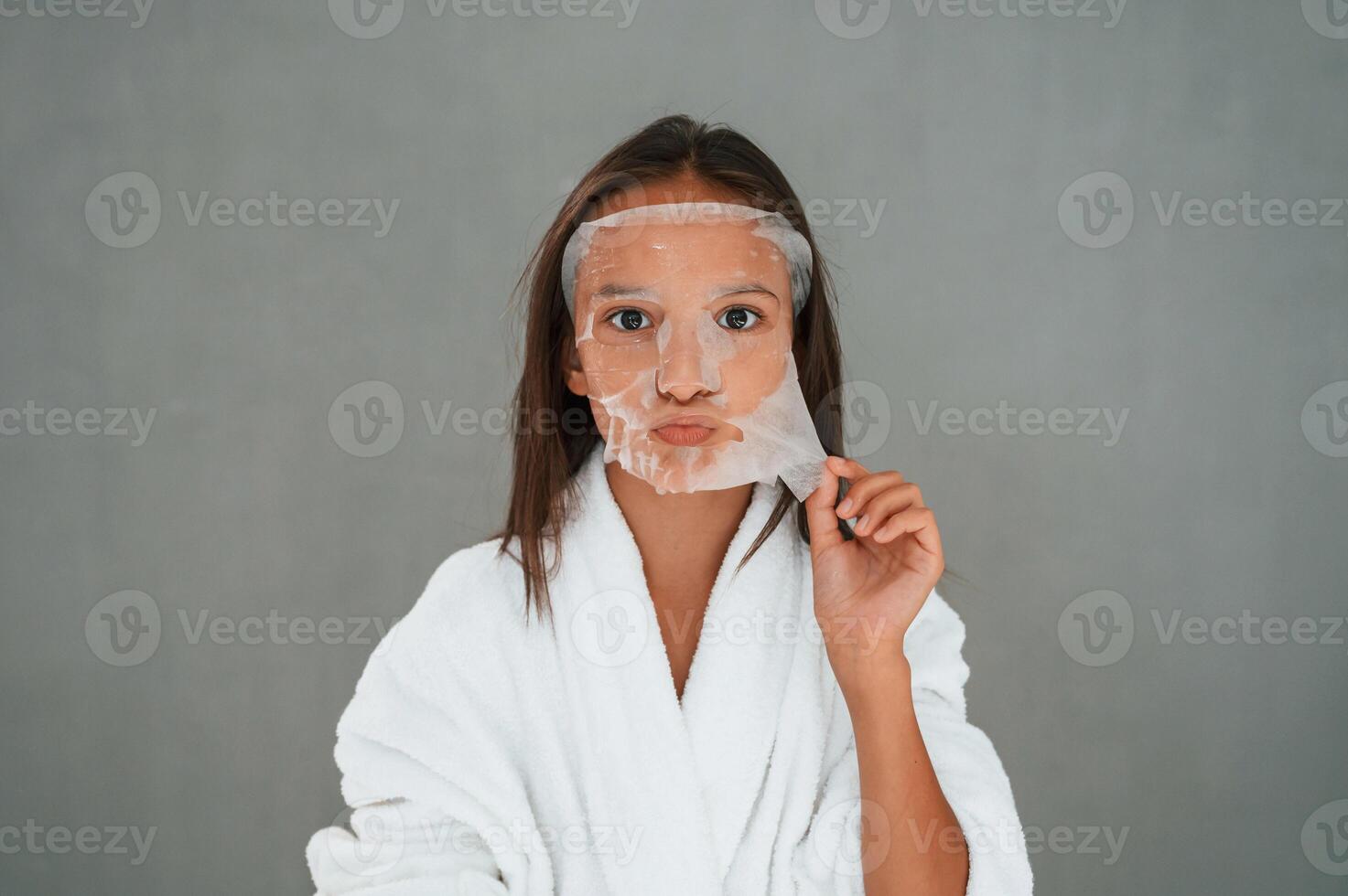 Funny, facial, expression.. Playing with mask. Conception of beauty. Young girl is in the studio photo