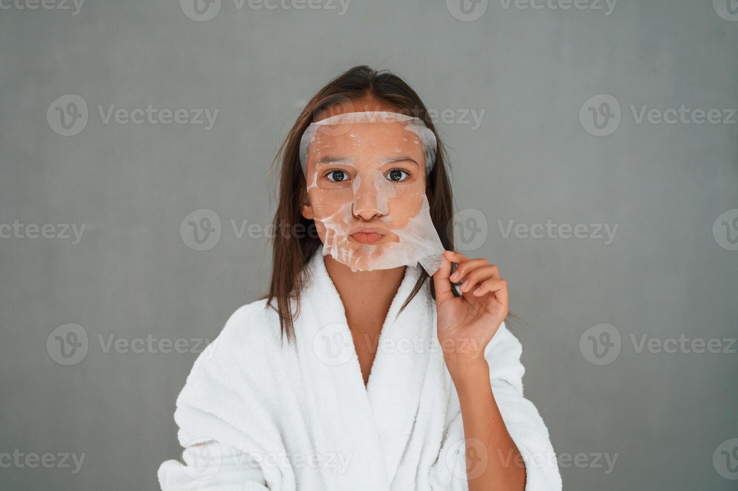 Cleaning mask, is on the face. Conception of beauty and self care. Young girl is in the studio photo