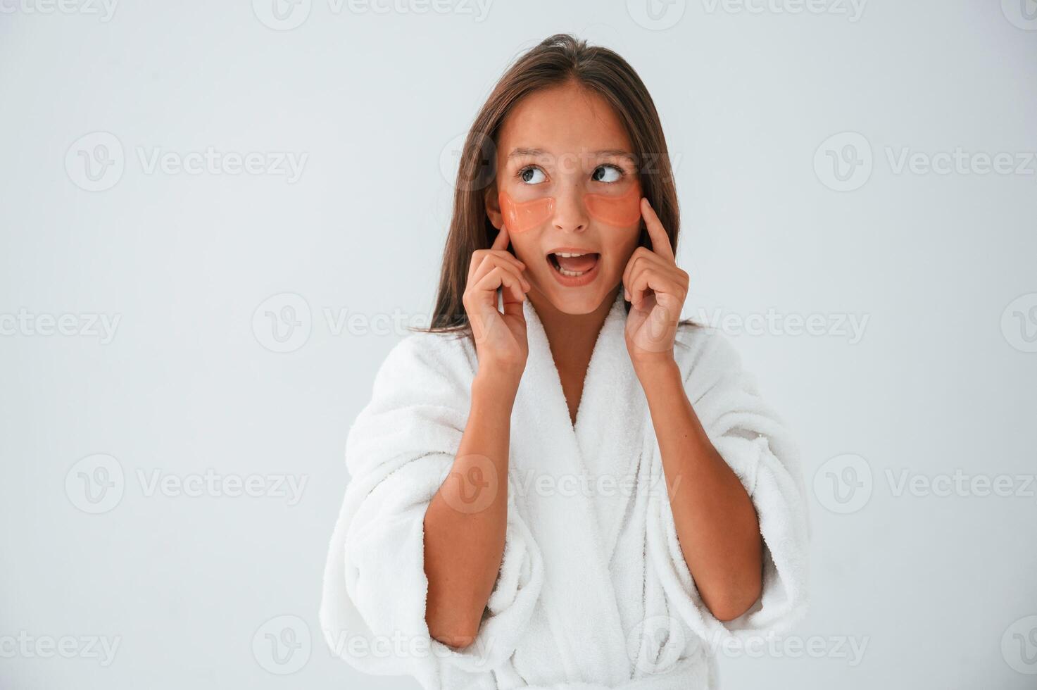 Positive, and surprised facial expression. With eye patches. Conception of beauty. Young girl is in the studio photo