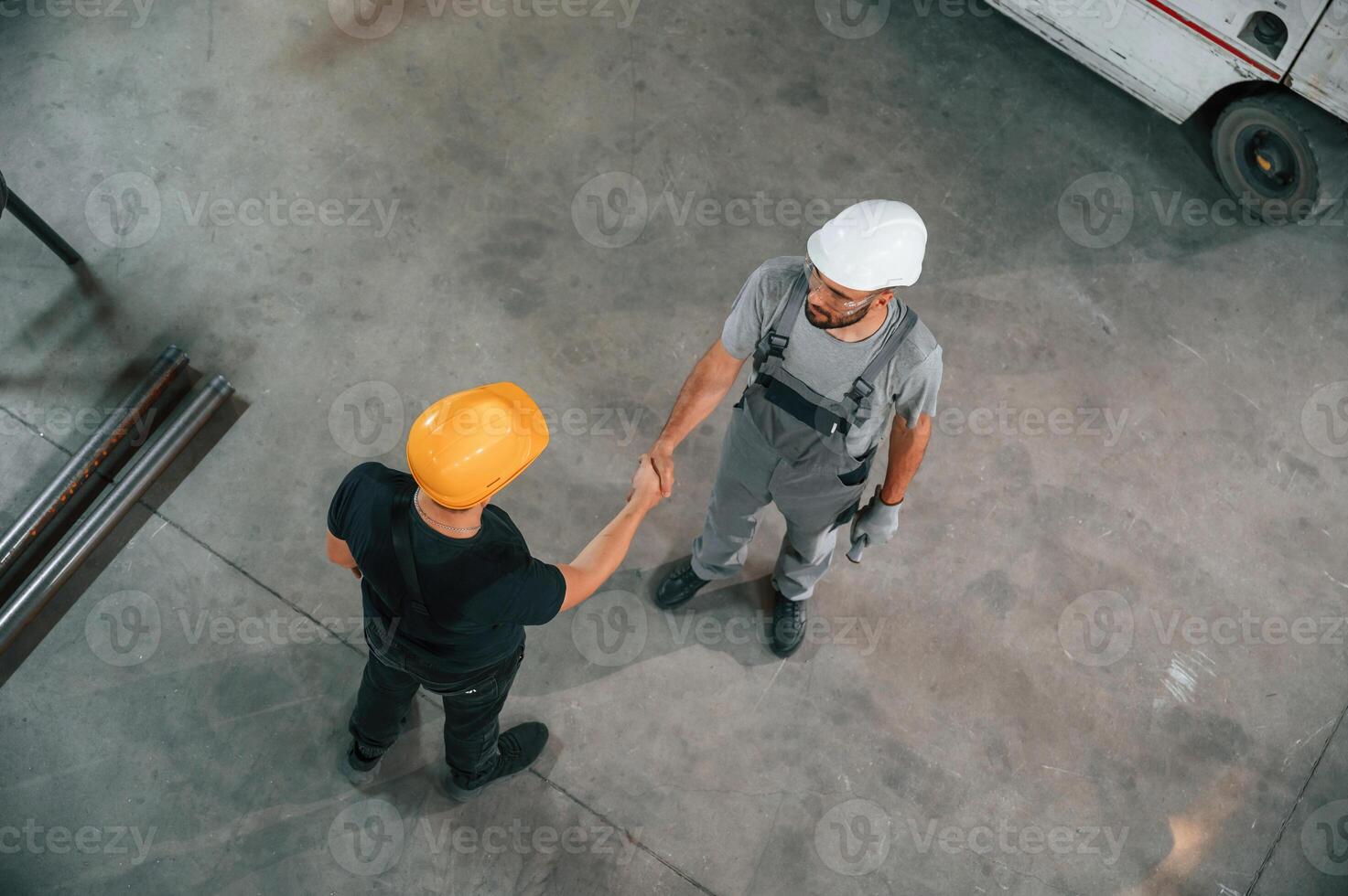 Top view of two factory, workers, that are standing and making handshake, business deal photo