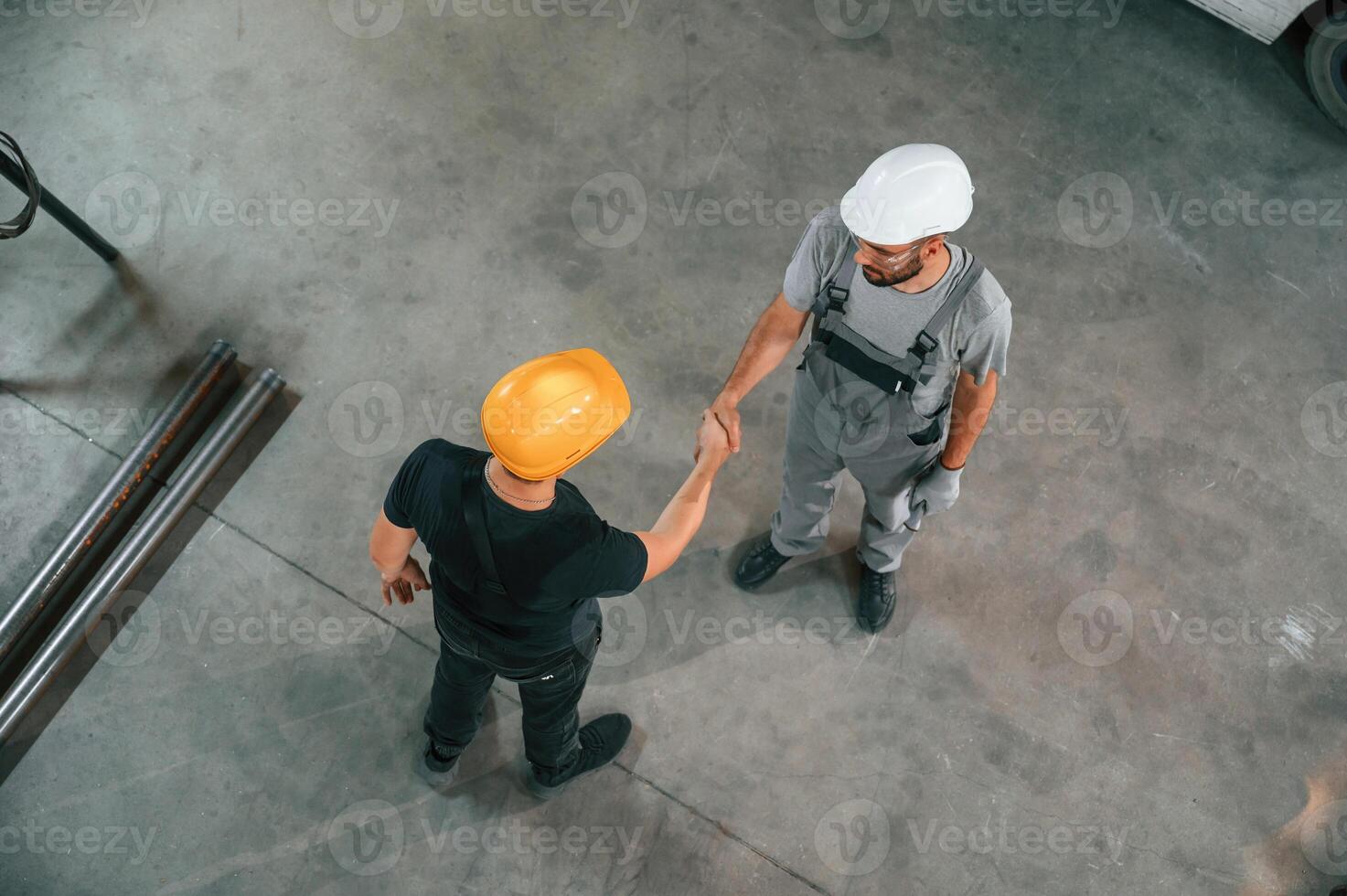 Top view ,of two ,factory workers that are standing and making handshake, business deal photo