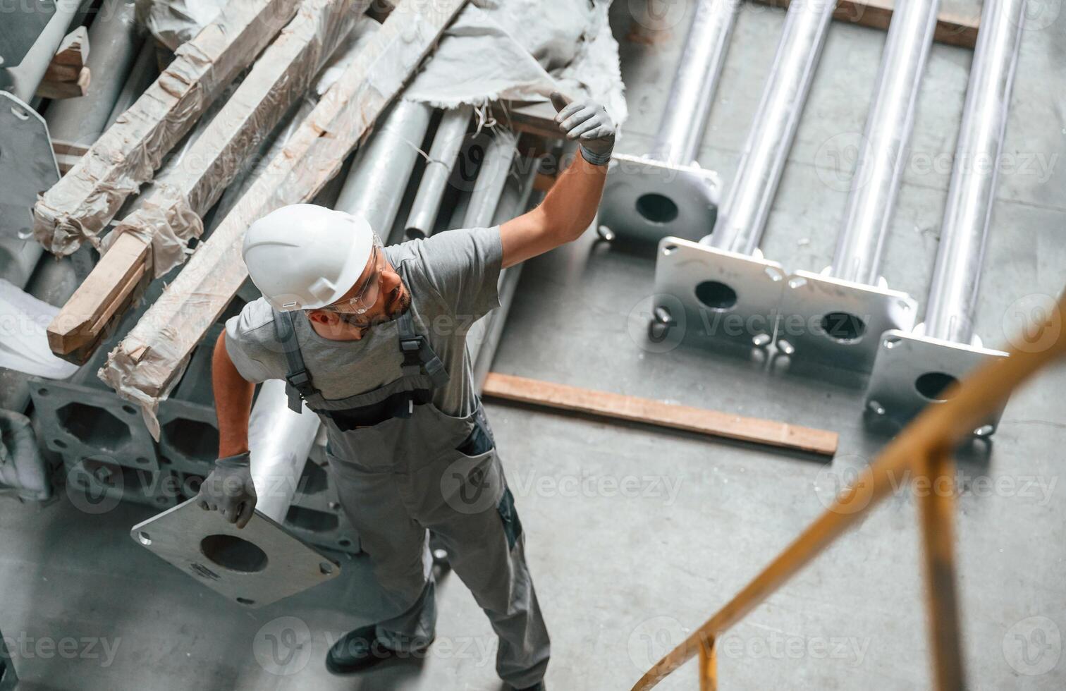 Making ,gesture by hands.. Young factory worker in grey uniform photo