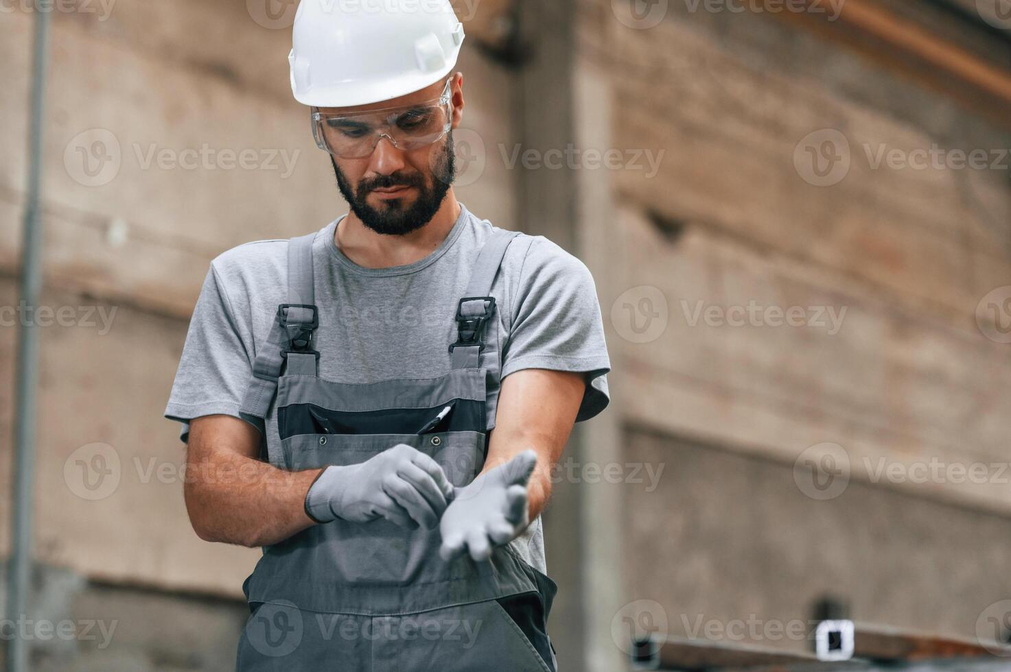 Young factory worker in grey uniform., photo