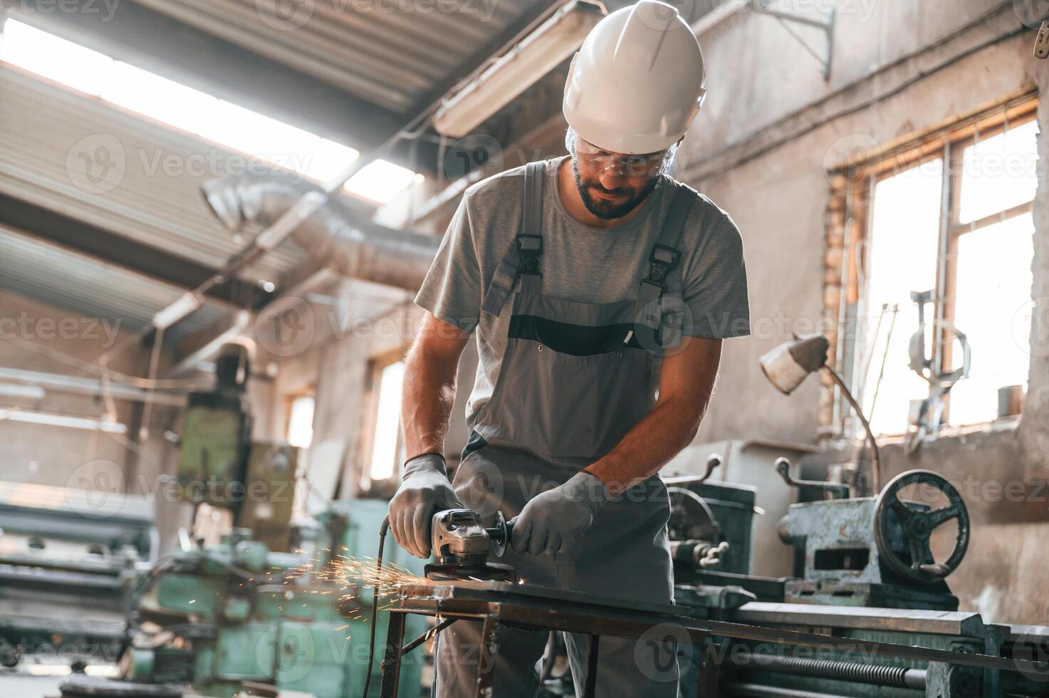 Busy ,day. Young, factory worker in grey uniform photo