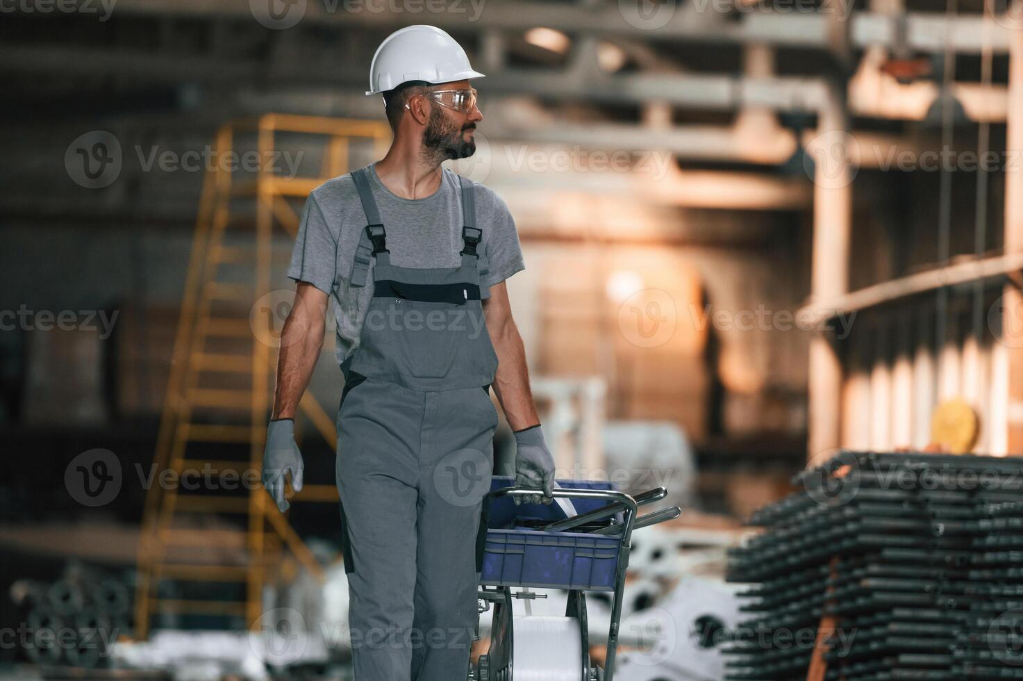 Front, view, walking, forward.. Young factory worker in grey uniform photo