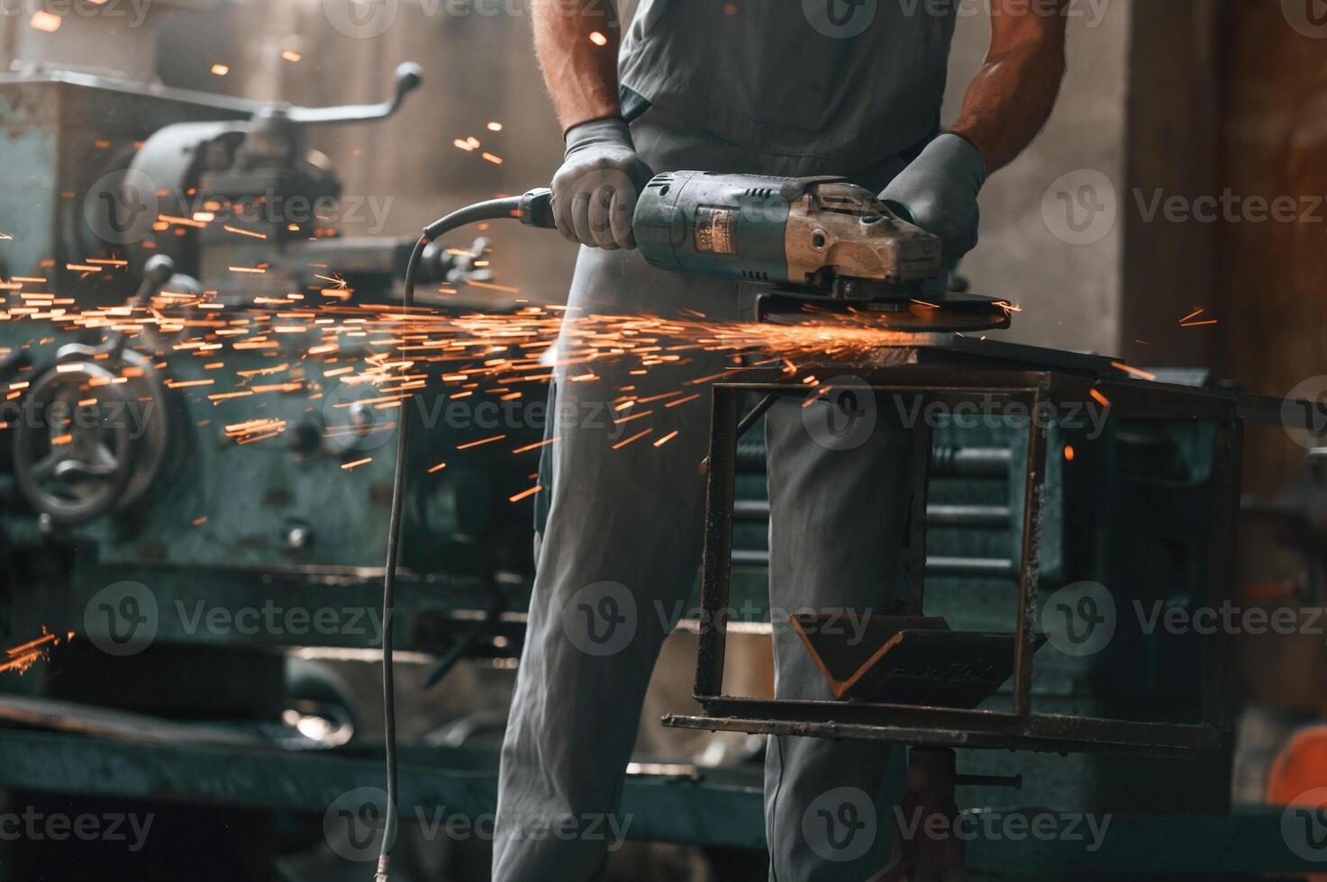 Polishing, the, surface, with angle grinder. Close up view of man that is working at the factory photo