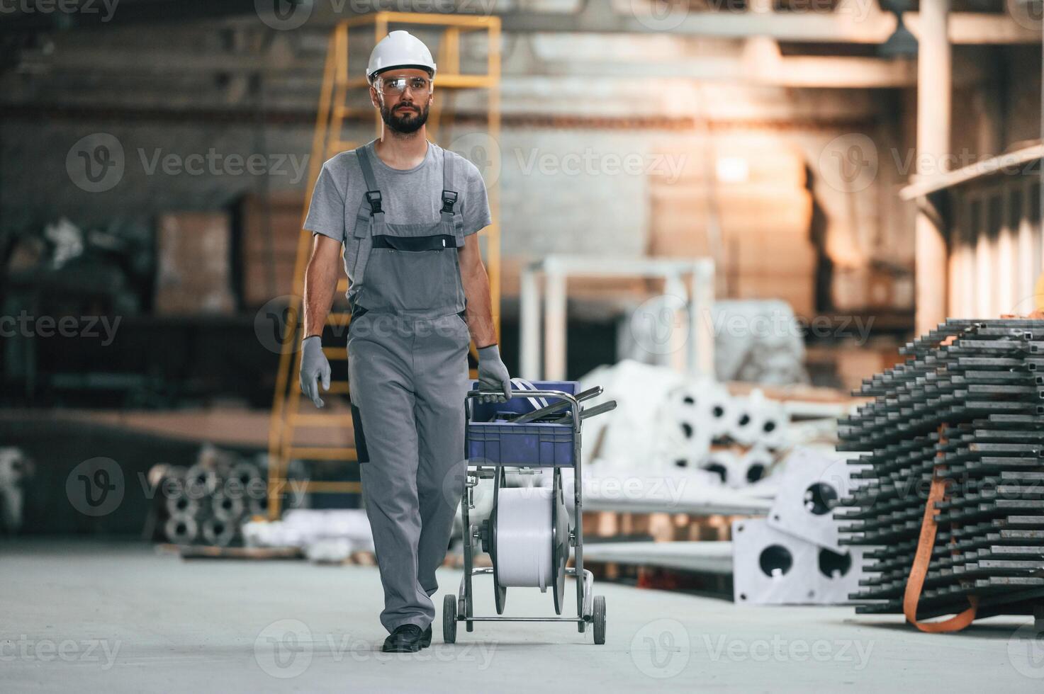 Front ,view, walking forward. Young factory worker in grey uniform photo