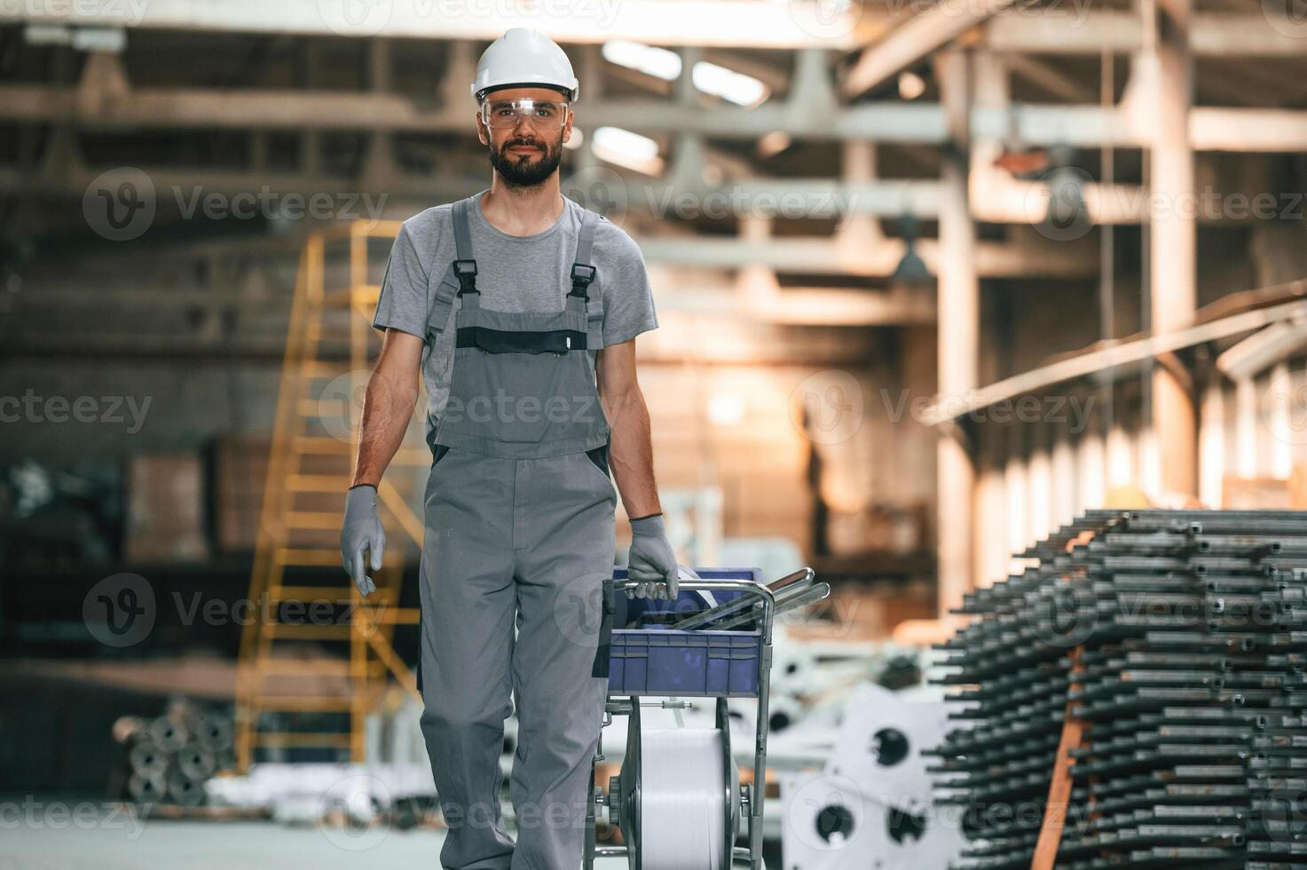 Front ,view,, walking forward. Young factory worker in grey uniform photo