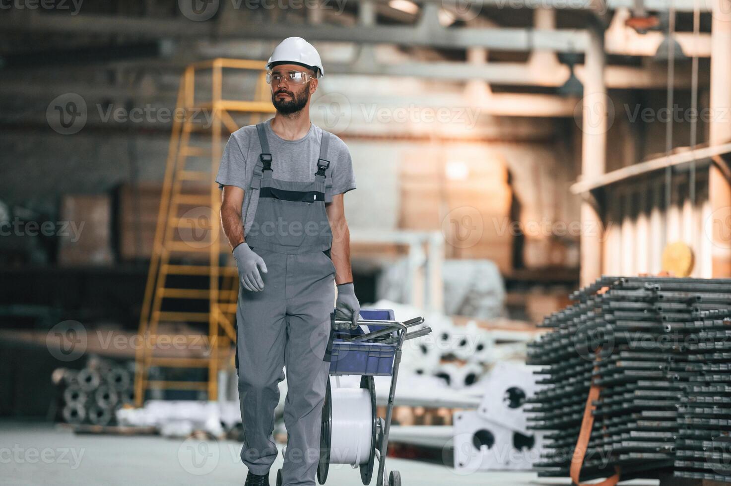 Front, view, walking, forward. Young factory worker in grey uniform photo