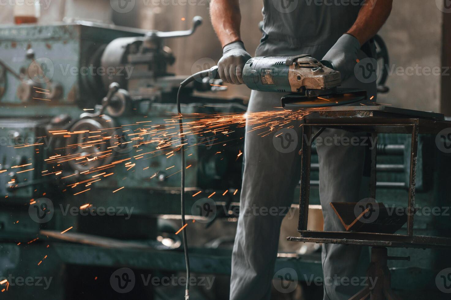 Polishing, the, surface with angle, grinder.. Close up view of man that is working at the factory photo