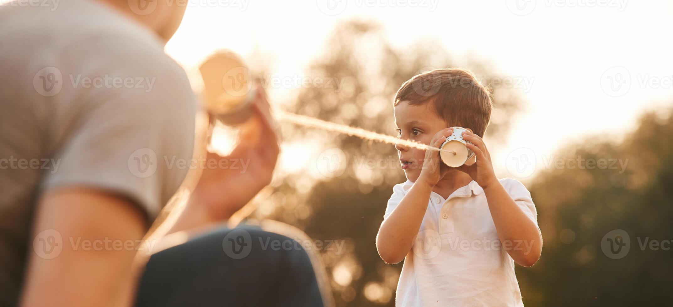 With, string ,can phone. Father and little son are playing and having fun outdoors photo