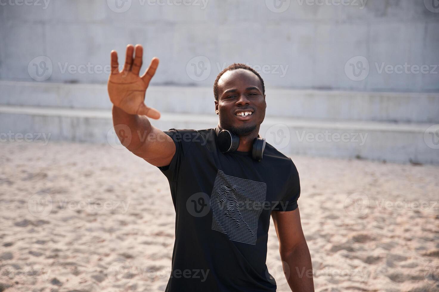 Greeting ,hand. Handsome, black man is posing outdoors at daytime photo