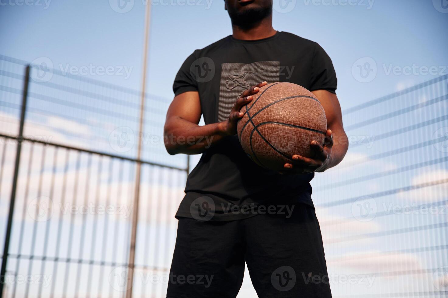 Natural, lighting. Young black man i,s with basketball ball outdoors photo