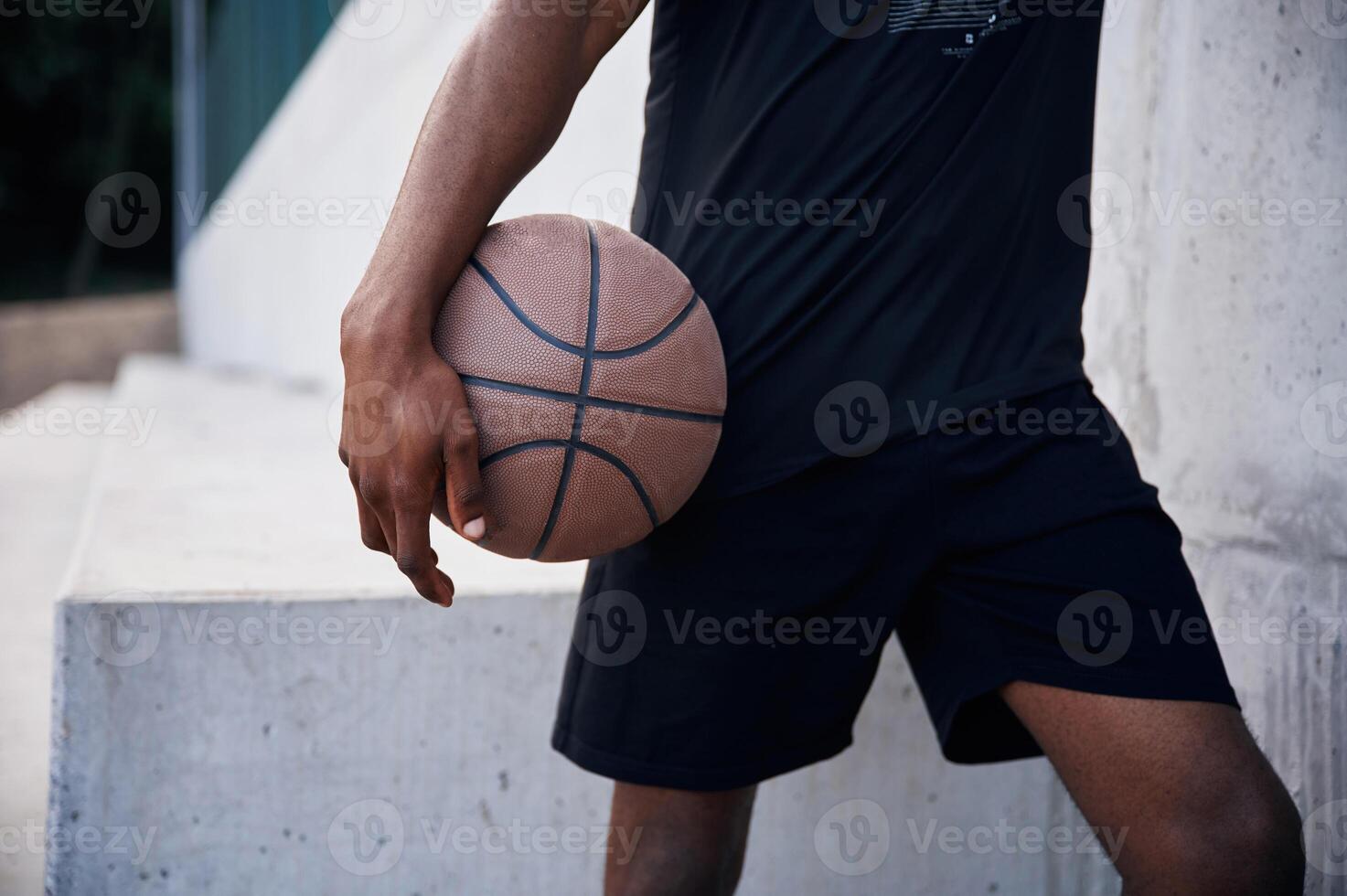 Close up view. Young black man is with baske,tball ball outdoors photo