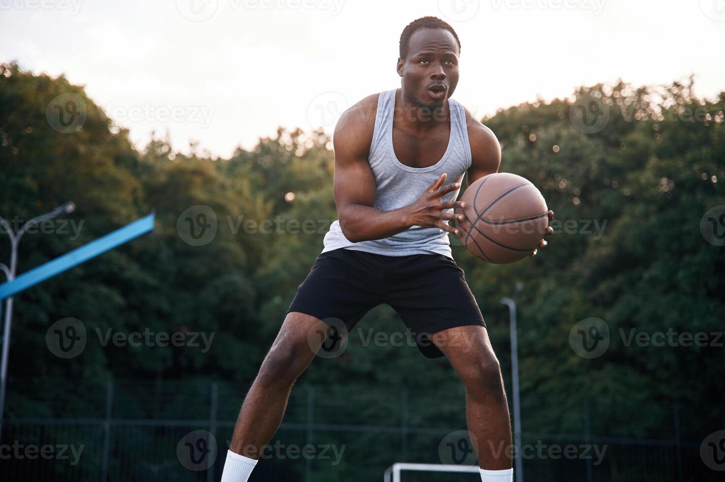 Playing, the game. Young black man is with basketball ball outdoors photo