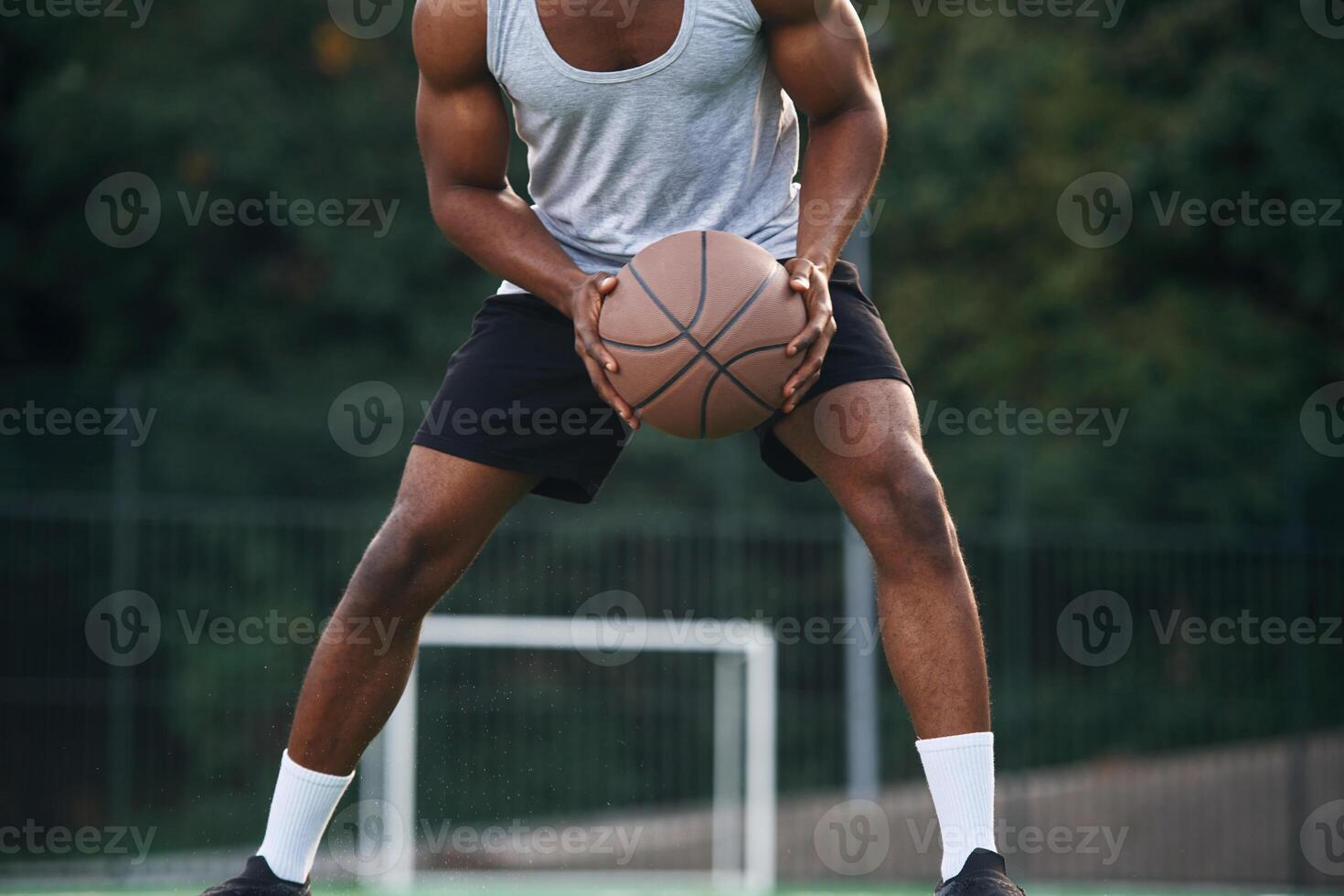 Front ,view. Young, black man is with basketball ball outdoors photo