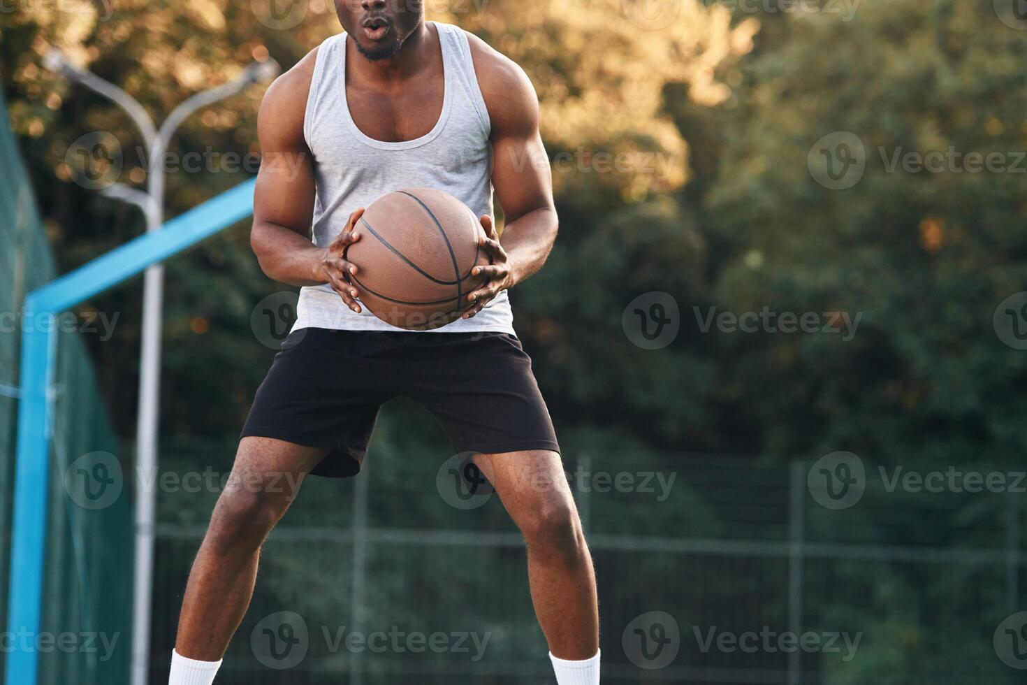 Front view.. Young black ma,n is with basketball ball outdoors photo
