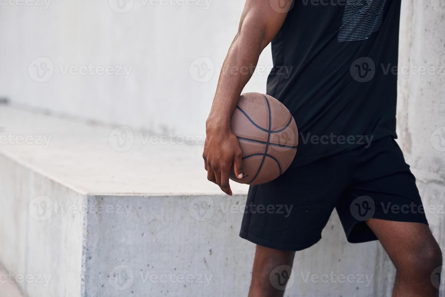 Close, up view. Young black man is with basketball ball outdoors photo