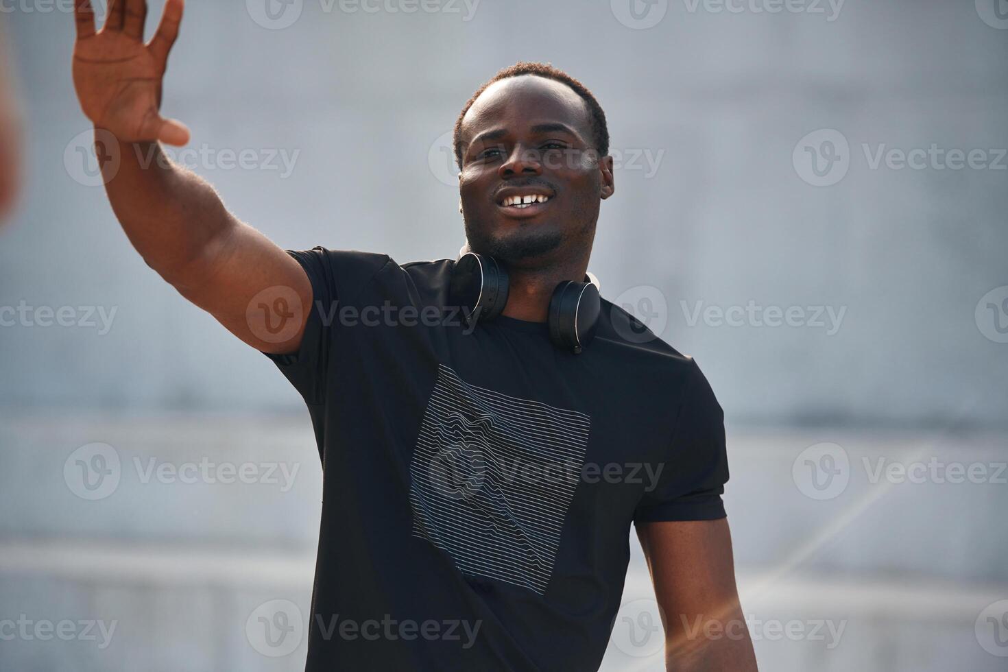Greeting, hand. Handsome black man is posing outdoors at daytime photo