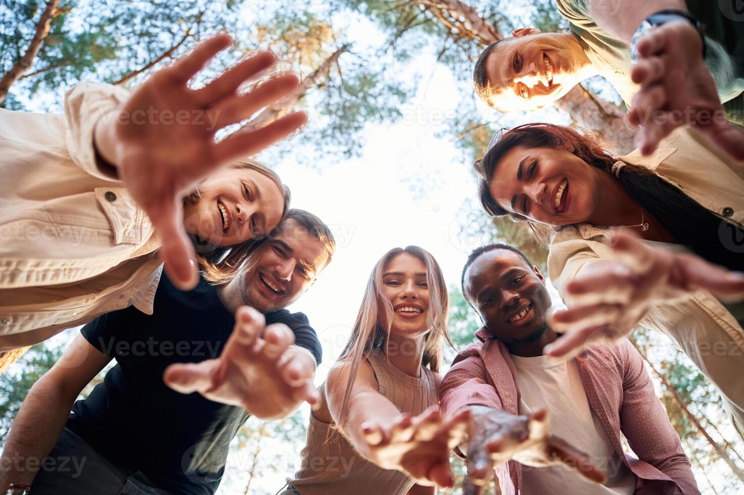 Looking down. ..View from below of group of friends that are in the forest photo
