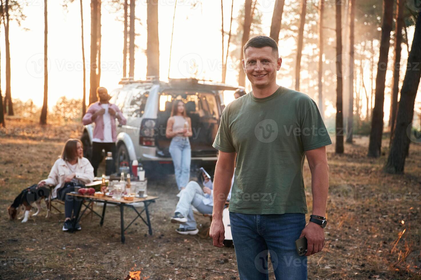 Happy man,, is smiling. Group of friends are together in the forest photo