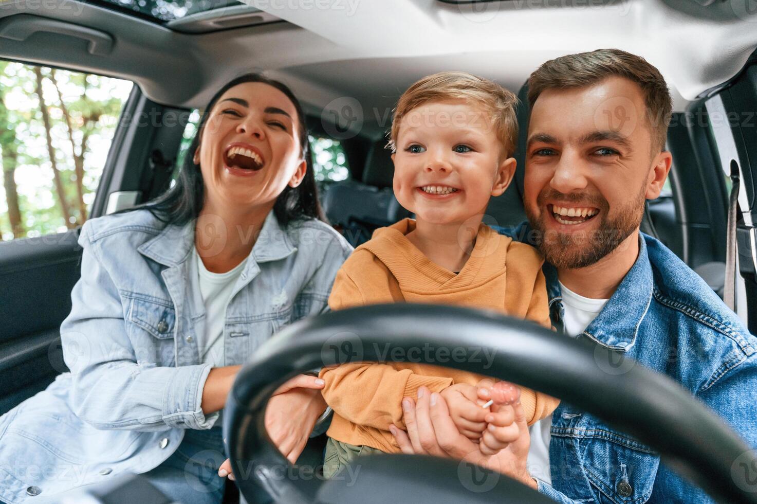 Family of father, mother and little son ,are ,sitting in the modern car photo