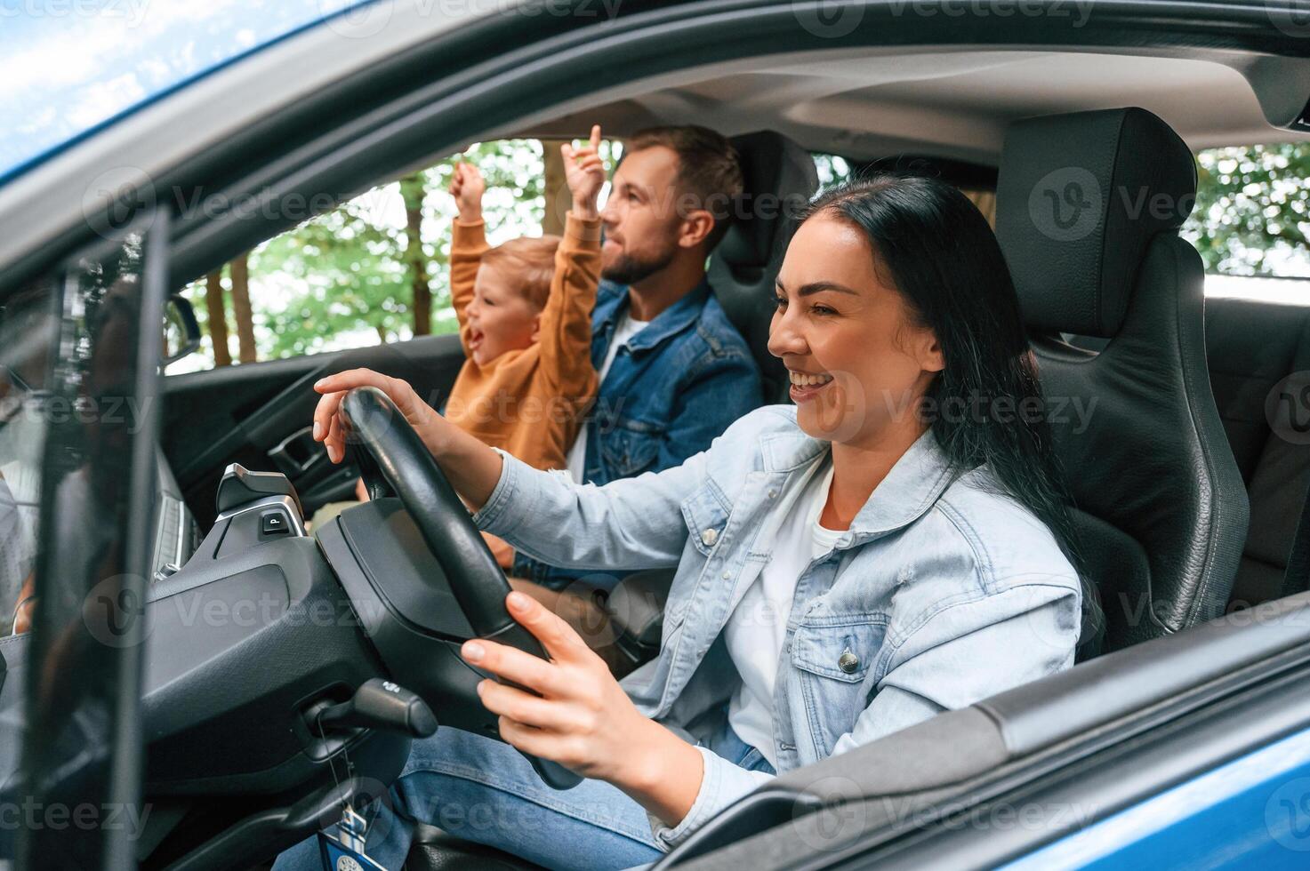 On a trip. Family ,of ,ather, mother and little son are sitting in the modern car photo