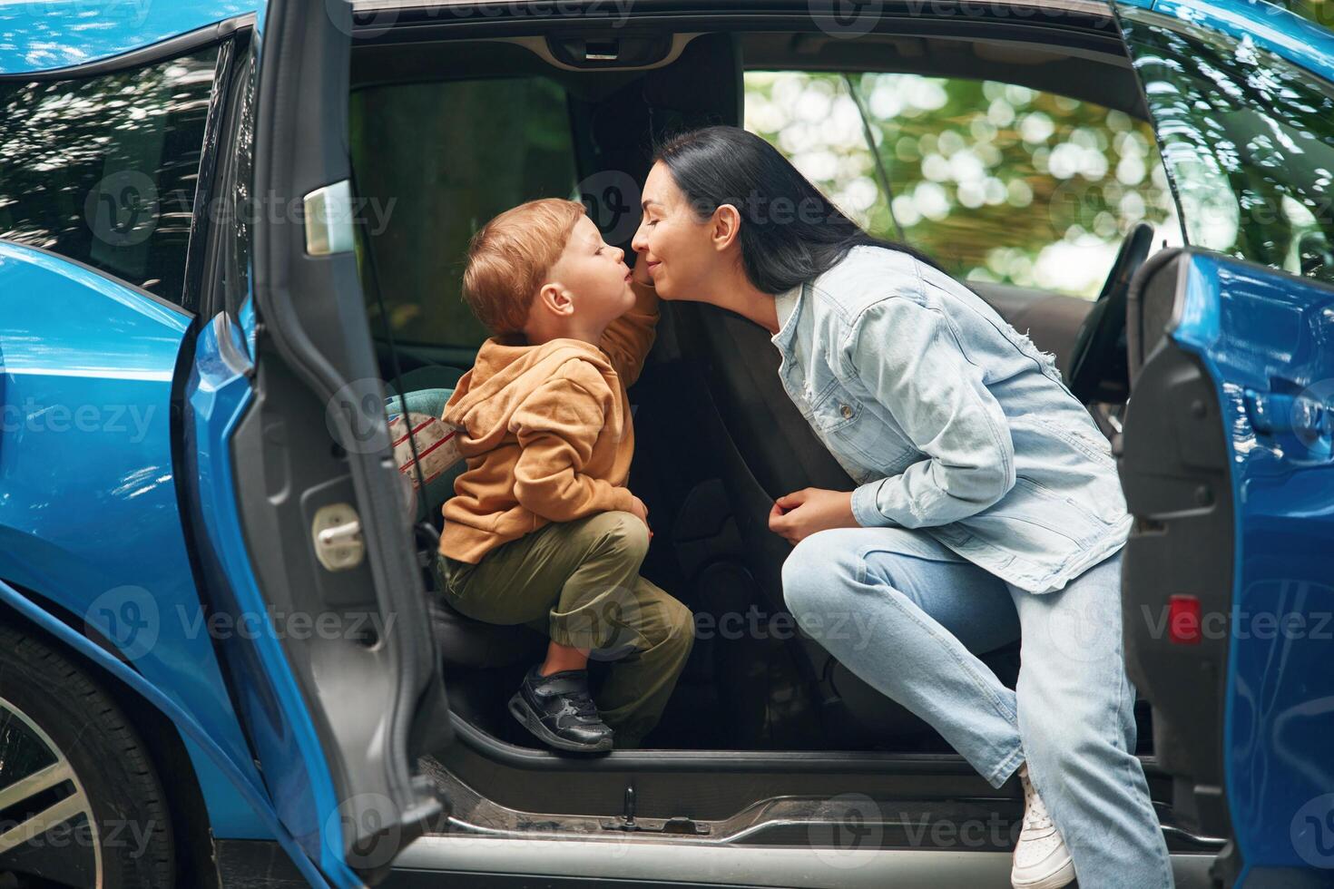 Mothe,r with her little son are in the modern car, having fun photo