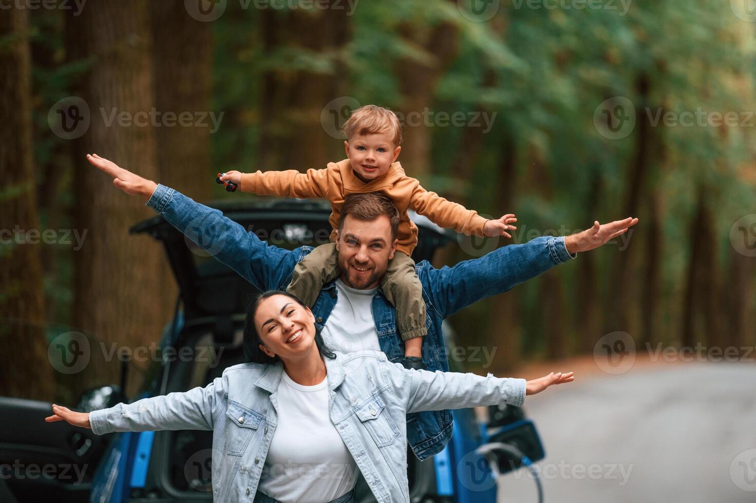 Happy, family.., Mother, father and little son are waiting for electric car to charge outdoors photo