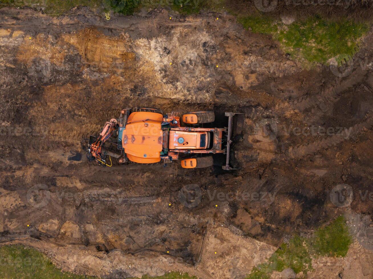 Overhead View of Orange Excavator at Construction Site with Soil photo