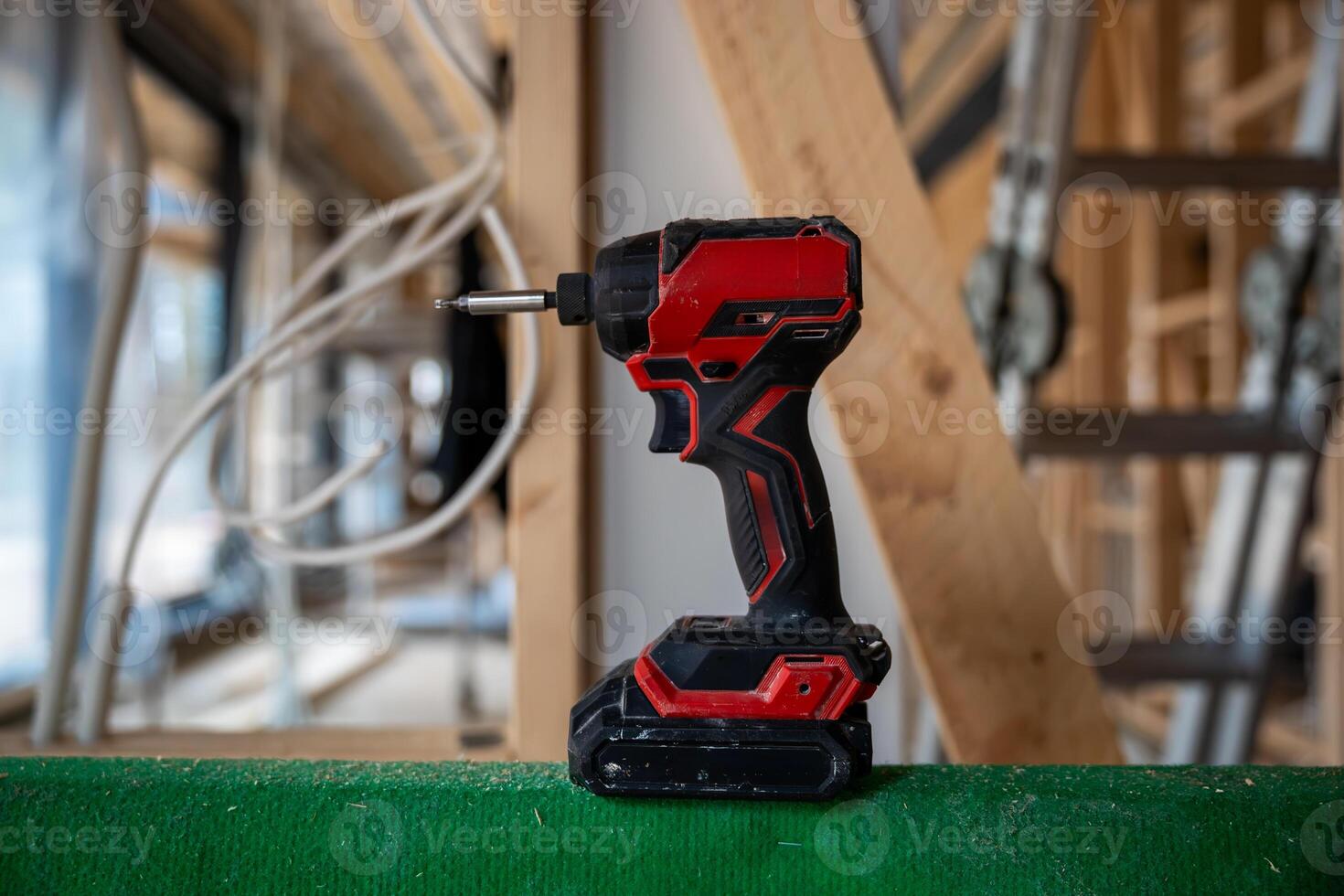 Cordless Power Drill on Green Surface in Partially Built House Interior photo