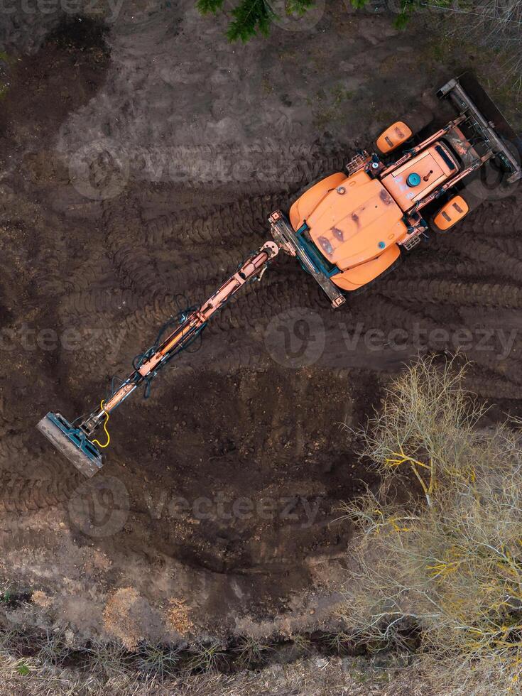 Aerial View of Construction Vehicle on Disturbed Soil with Sparse Vegetation photo