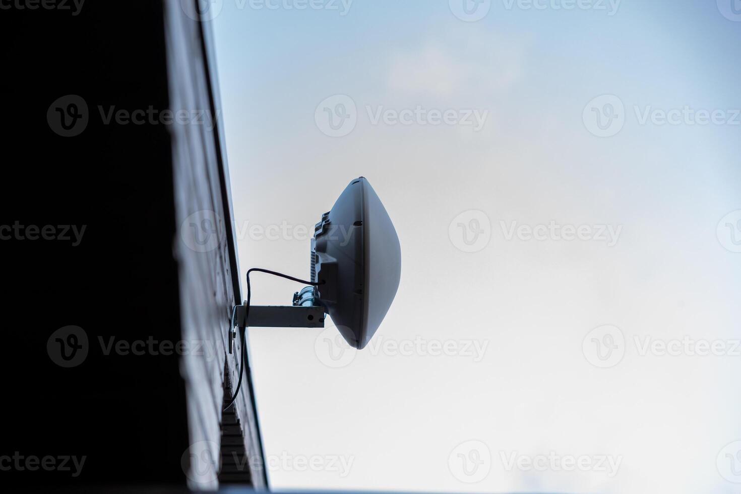 Mounted Wi Fi Router on Exterior Wall Against Blue Sky photo