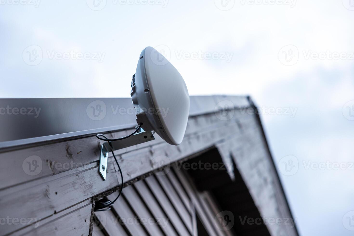 White Dome Shaped Wi Fi Router Mounted on Wooden House Exterior photo