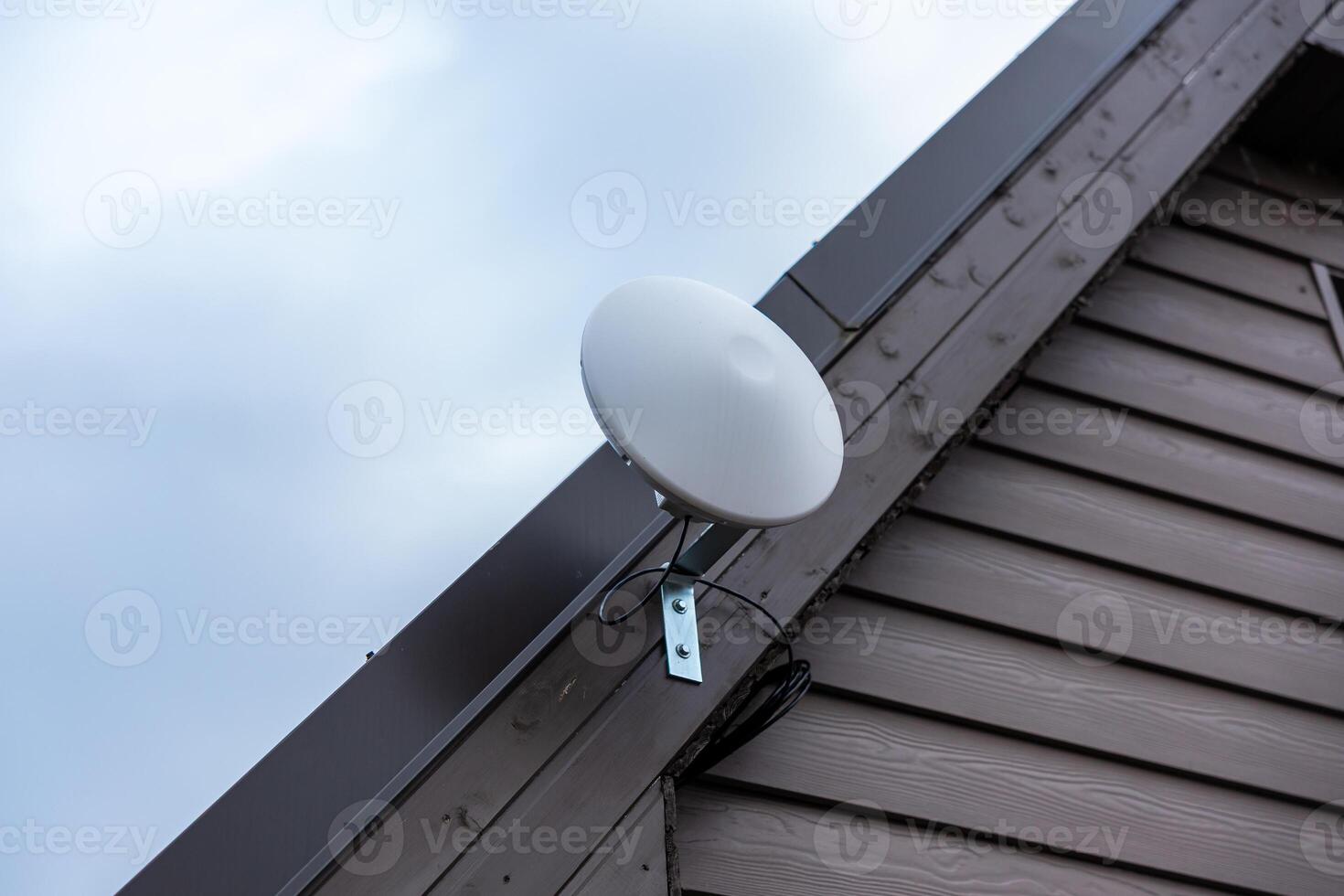 White Circular Wi Fi Router Mounted on Private House Exterior photo