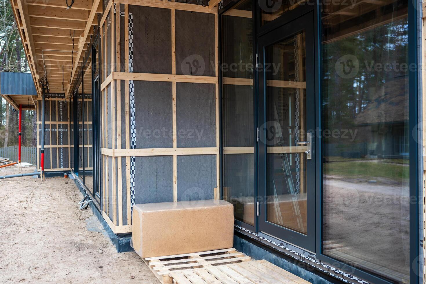 Modern House Under Construction with Wooden Framing and Glass Doors photo