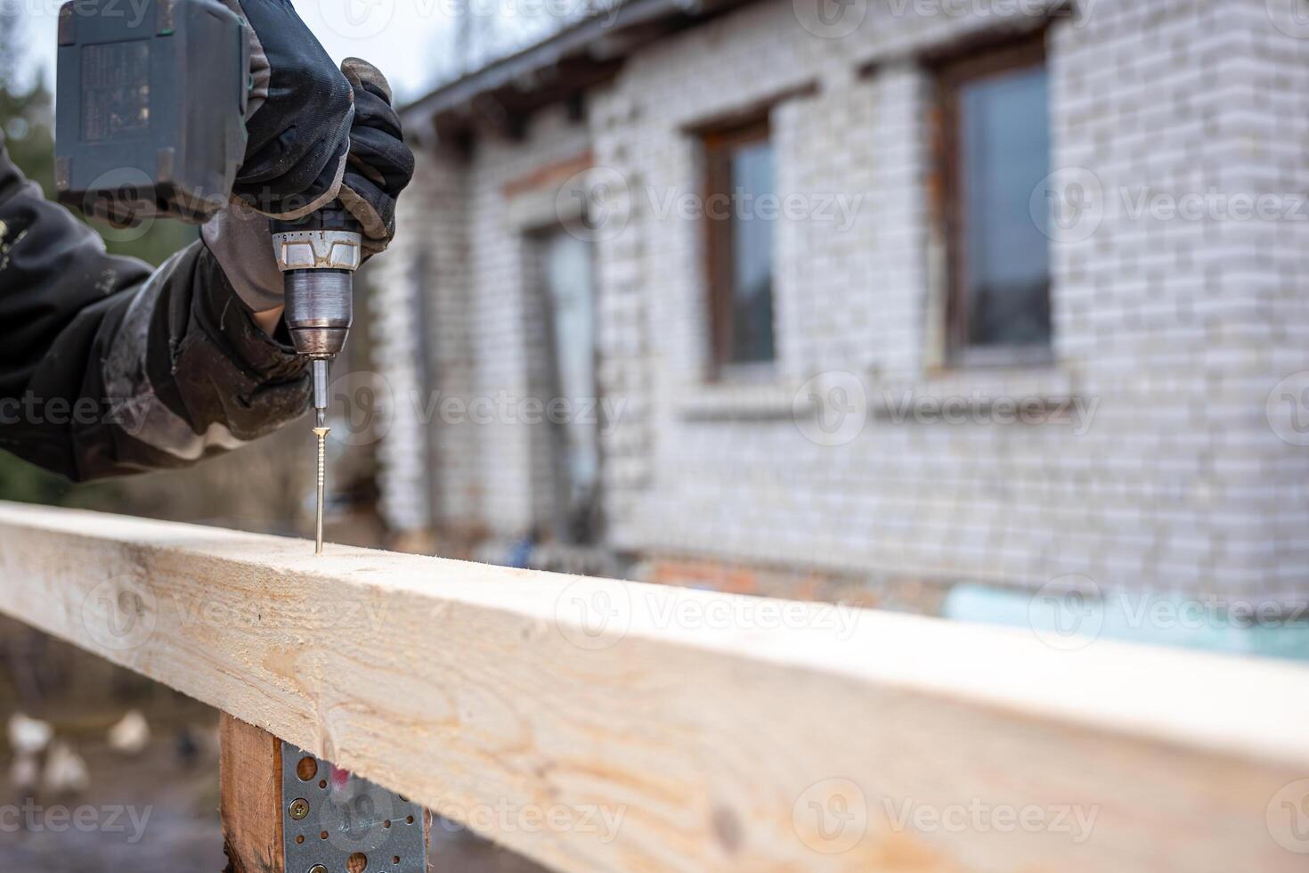 Close Up of Power Drill in Use with Brick Building in Background photo