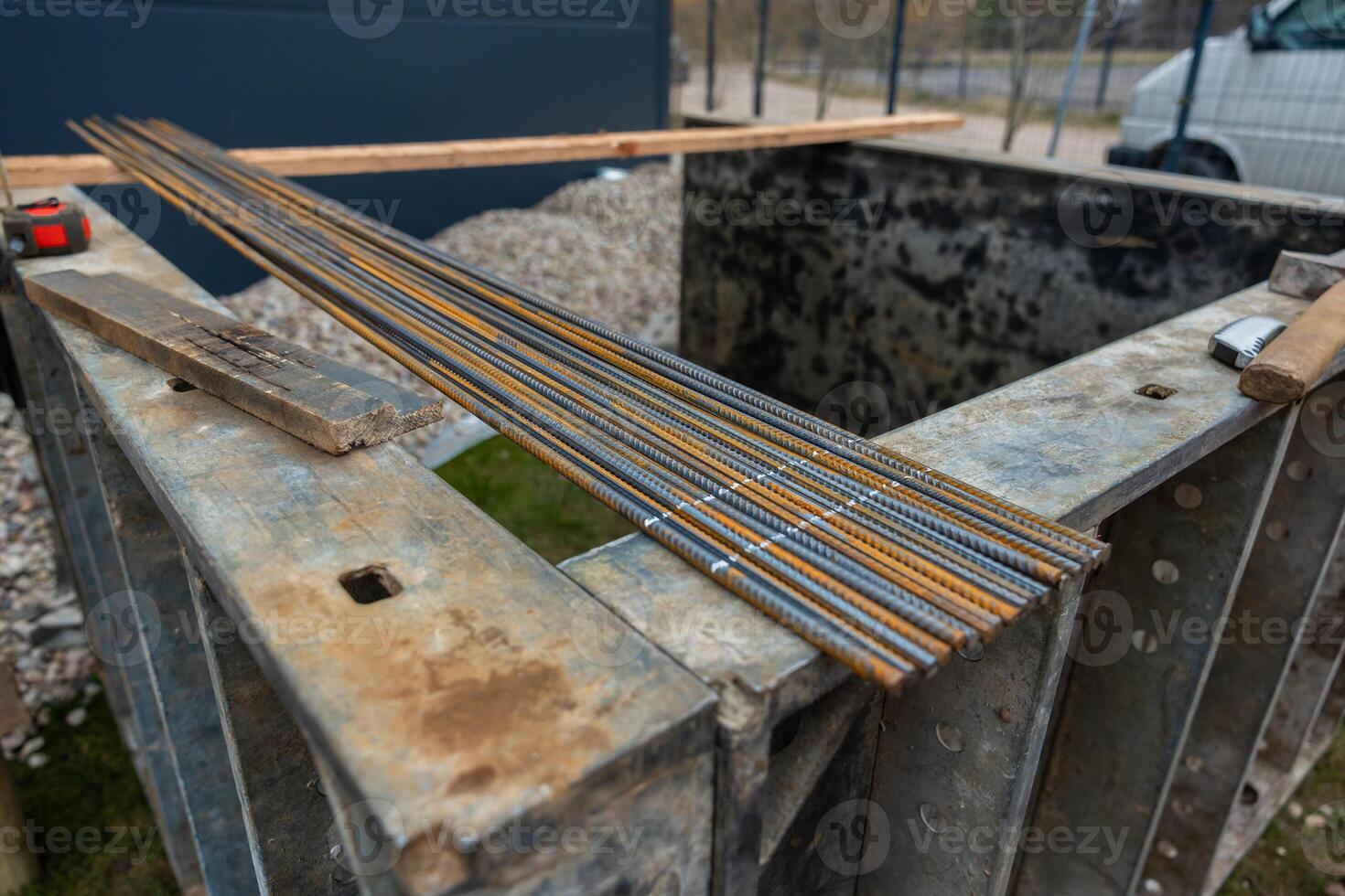 Rusty Steel Rebar Rods on Metal Workbench in Outdoor Construction Area photo