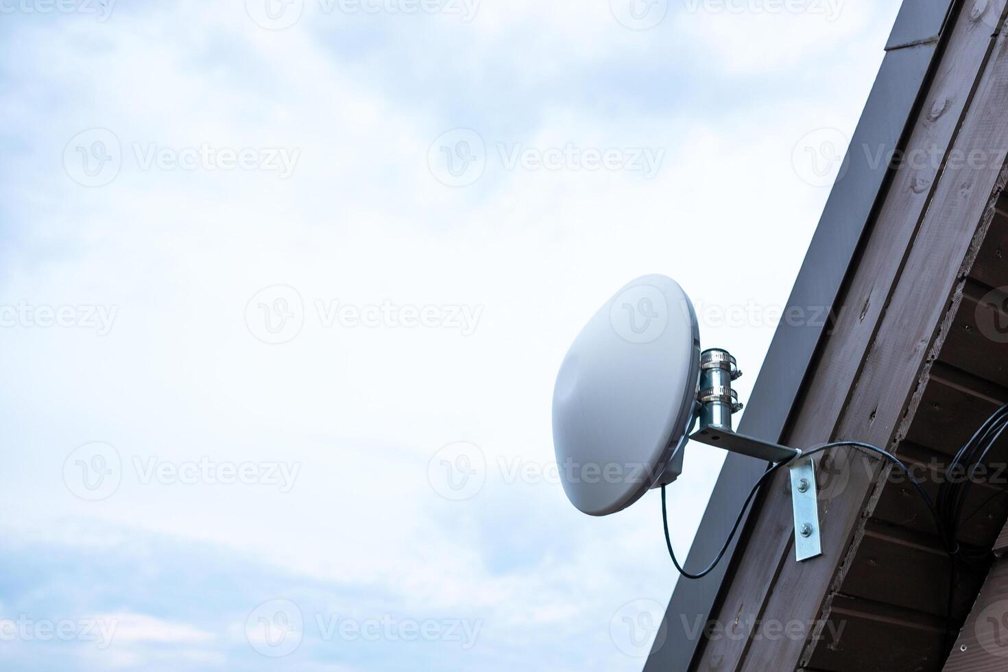 White Circular Wi Fi Router Mounted on Wooden House Exterior photo
