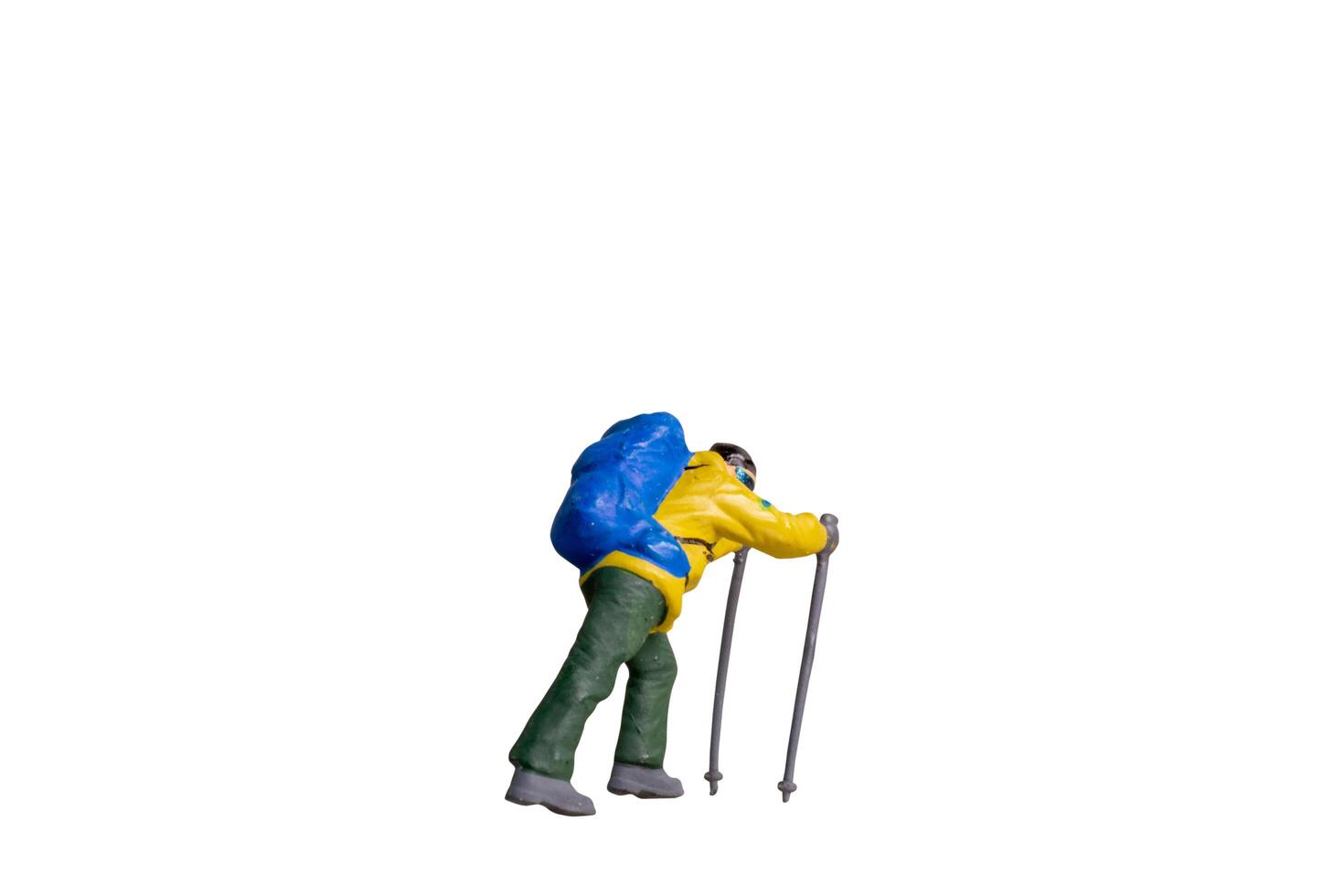 Miniature Figurine of Trekker with Hiking Poles isolated on white background with clipping path photo