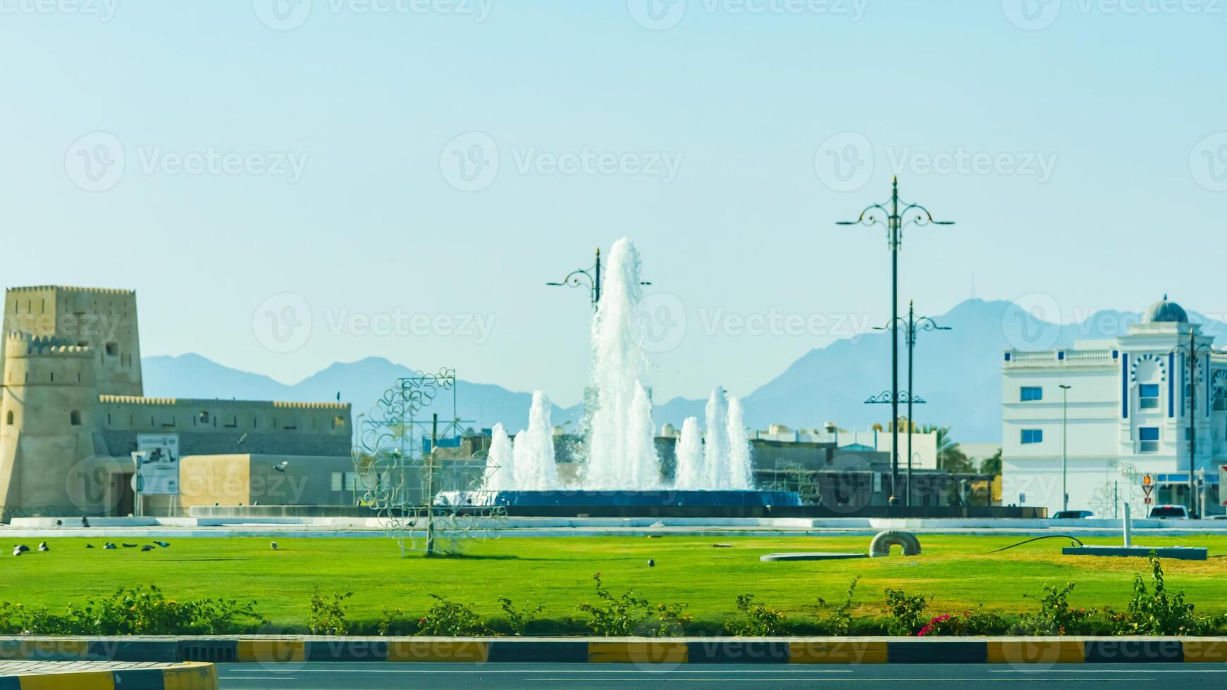A city with a fountain in the middle of it photo