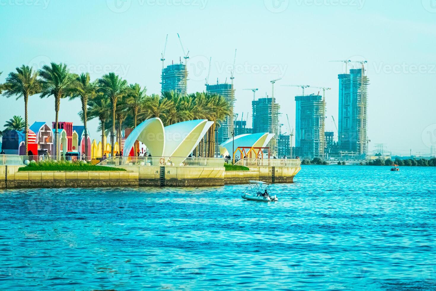 A body of water with palm trees and a boat photo
