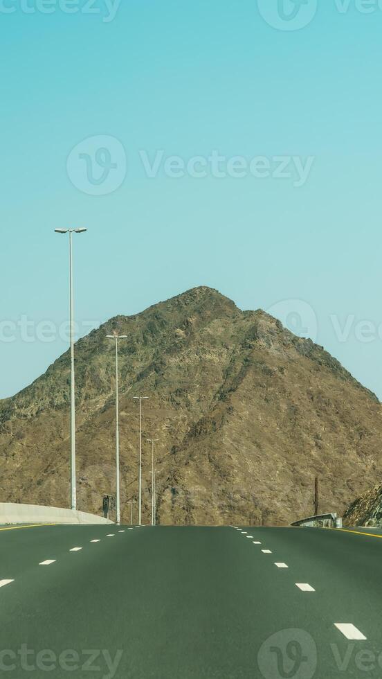 An empty highway with a mountain in the background photo