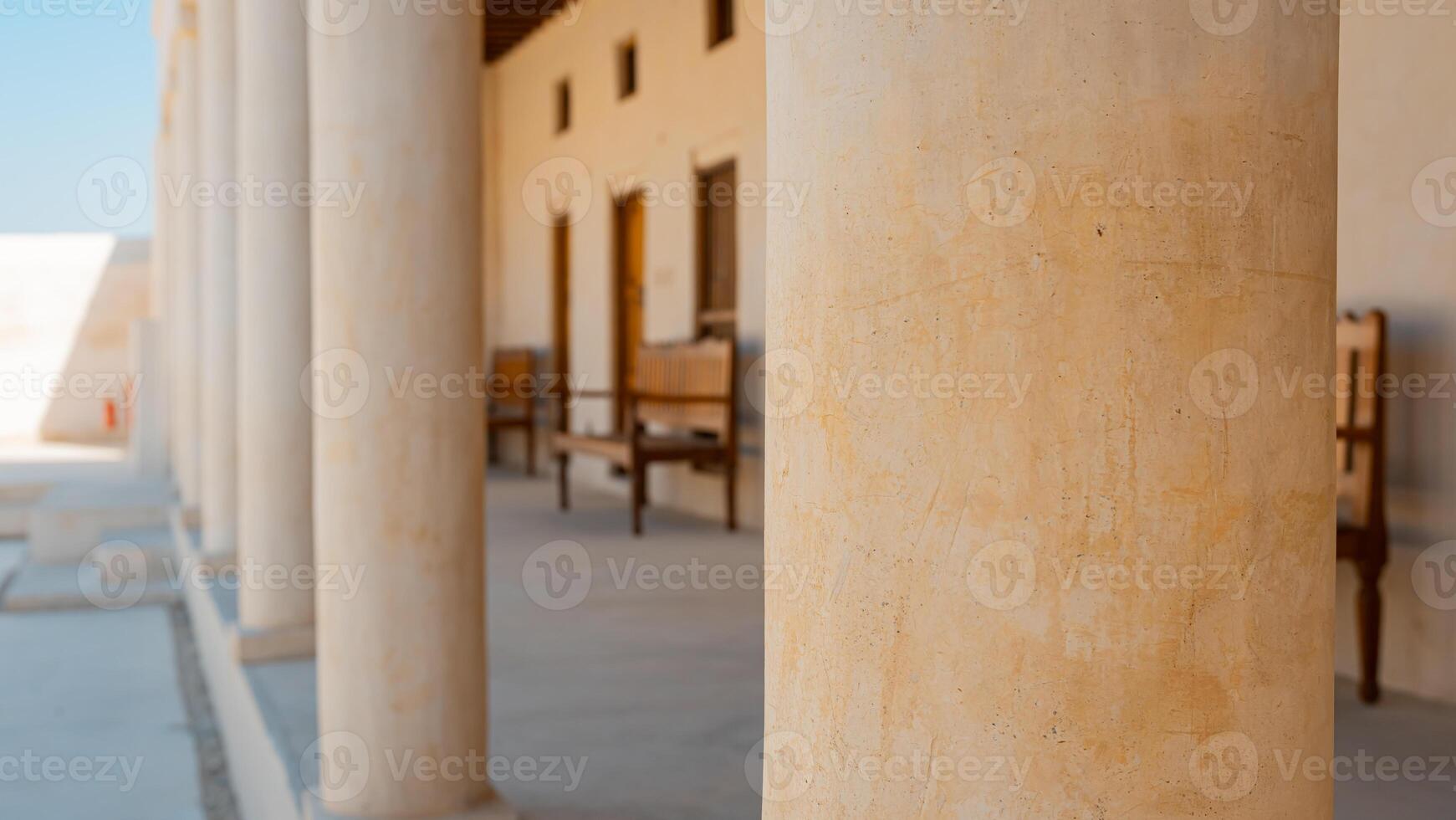 A man sitting on a bench in front of a building photo