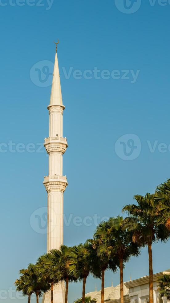 A white mosque with a tall tower photo