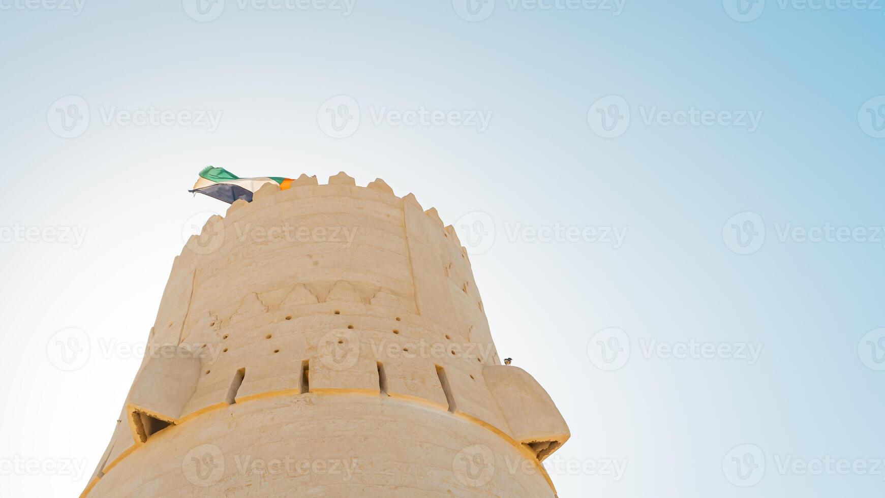 A tower with a flag flying in the air photo