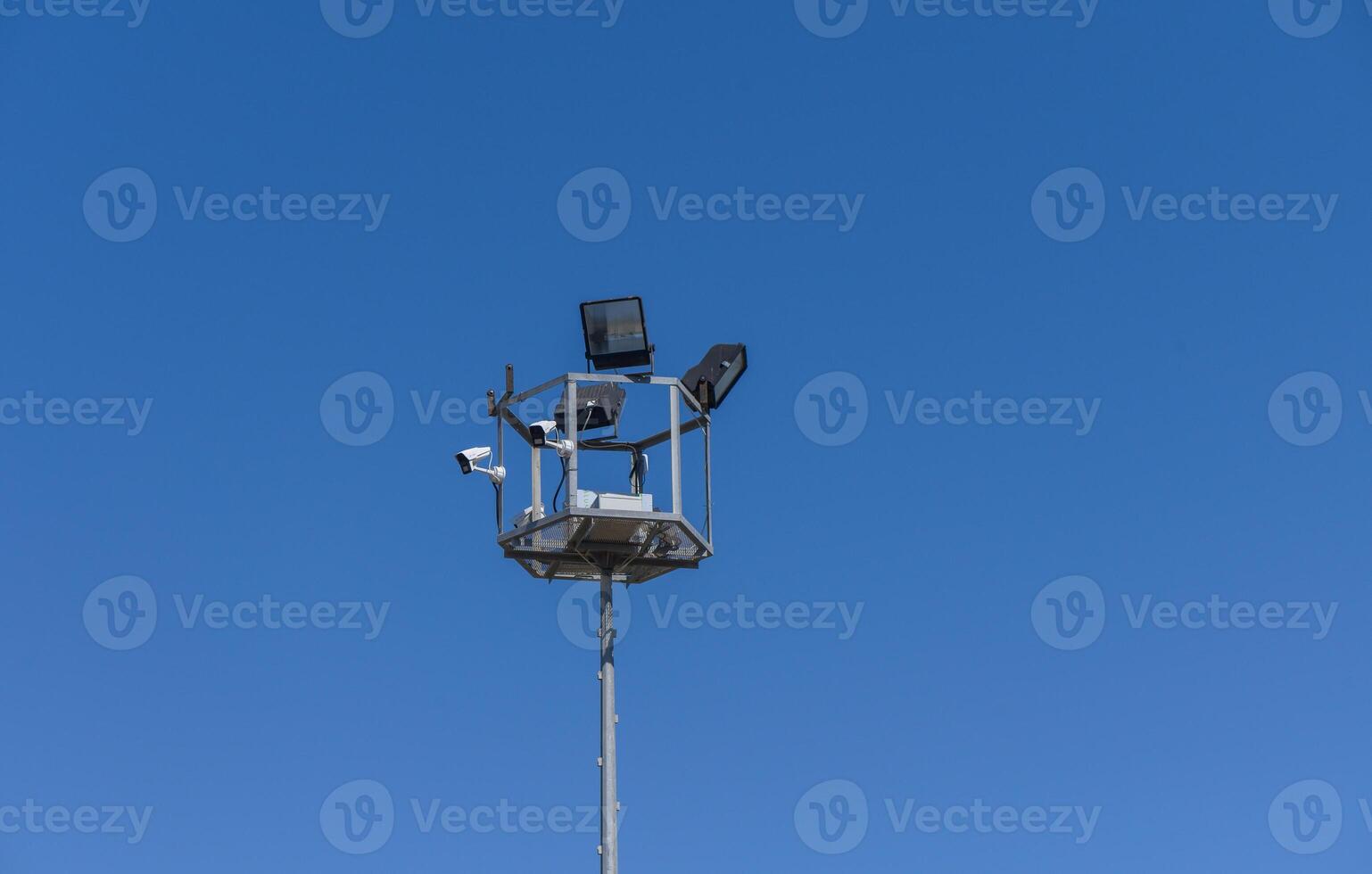 Surveillance tower monitoring the environment under the clear blue sky with modern technology photo
