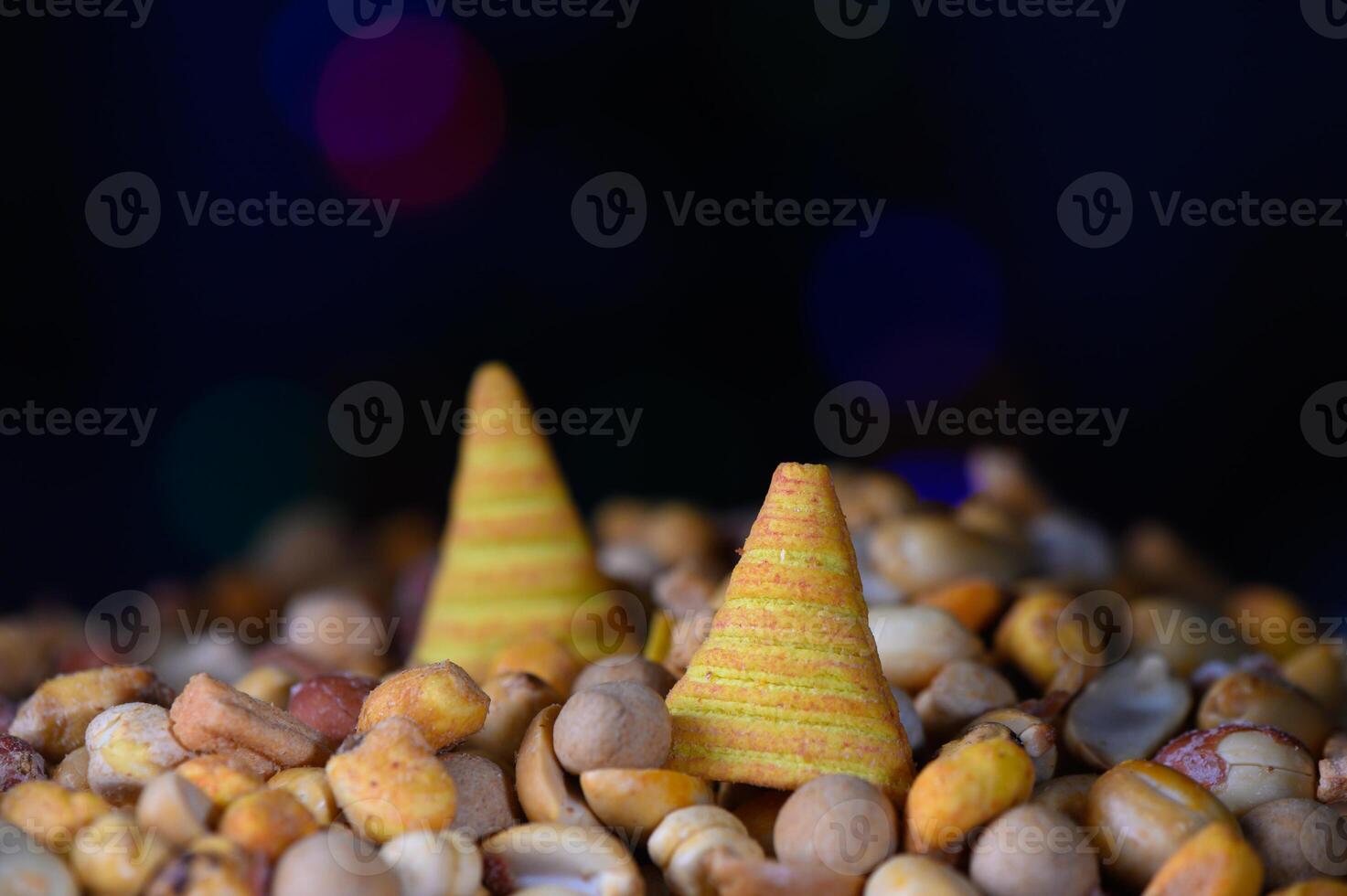 Colorful conical treats surrounded by a variety of vibrant nuts and seeds in a festive atmosphere photo