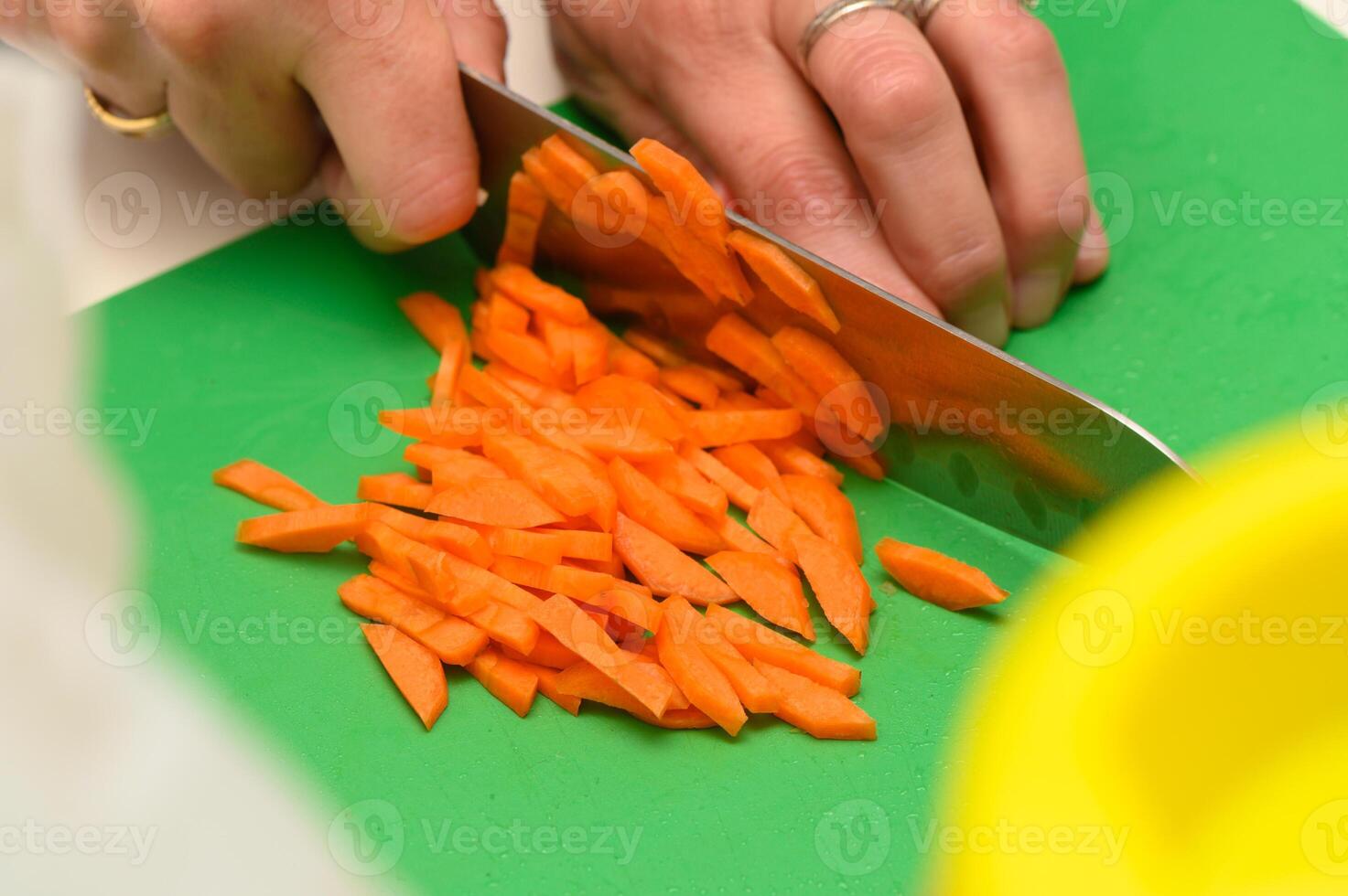 Slicing fresh carrots with precision in a cheerful kitchen during a sunny afternoon cooking session photo