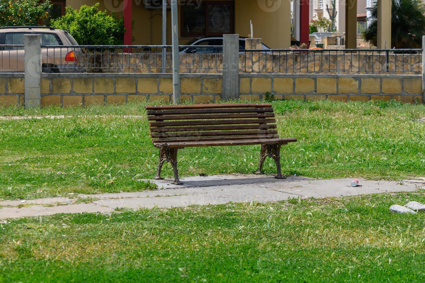Empty wooden bench in a sunlit park surrounded by lush green grass inviting moments of tranquility photo